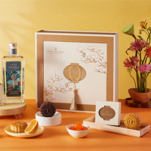 Hộp quà Trung Thu cao cấp từ InterContinental với thiết kế hoa mộc lan và đèn lồng, kèm chai rượu gin Lady Triệu và các loại bánh Trung Thu truyền thống.